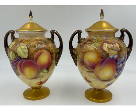 A pair of Royal Worcester porcelain urn shaped vases painted with assorted fruit, one signed C. Hughes. Both with black facto