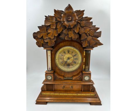 A late Victorian oak cased bracket clock by The British United Clock Company with integrated thermometer, compass and spirit 