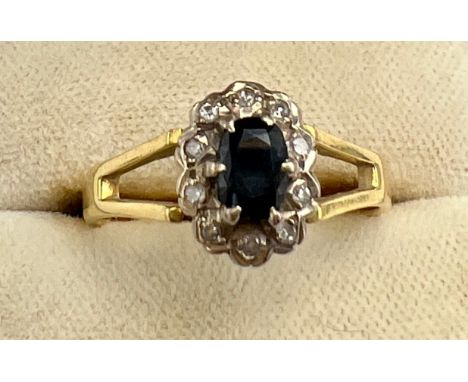 An 18 carat gold sapphire and diamond cluster ring with fork shoulders. Size R. Weight 3.8gm.