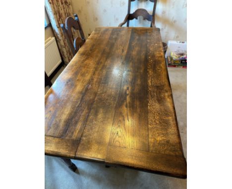 An oak table with single stretcher together with 6 ladder back chairs and two carvers. Table 182 l x 92w x 76.5cm h, chair 10