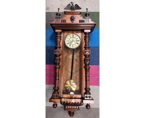 A Vienna twin weight wall clock with enamel dial, Roman numerals, a glazed door, pediment with carved eagle and carved 136cm 
