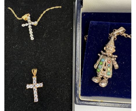 Nine carat gold chain and two 9 carat gold gem set crucifix, 2.2gm, together with a silver gem set clown on chain.