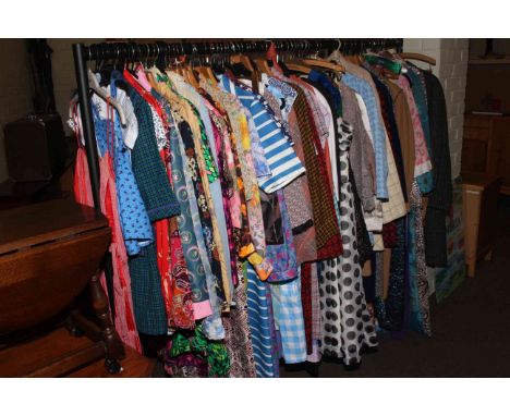 Rail of vintage clothing including dresses, coats, jackets, etc