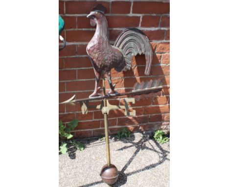 A brass weather vane with cockerel standing on an arrow