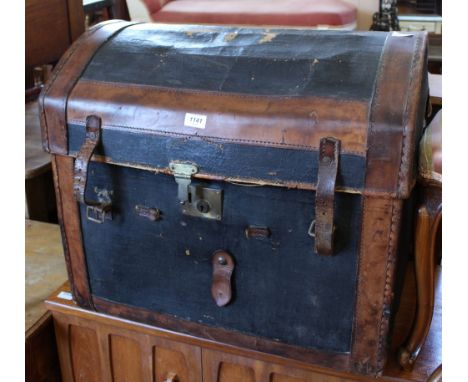 A vintage dome topped leather and canvas travelling trunk