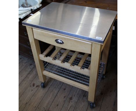 A modern food preparation island, with metal top, single drawer, shelf and wire tier underneath