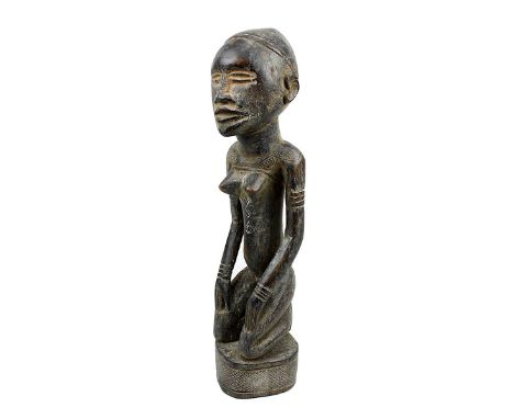 Kniende weibliche Figur wohl der Yombe, D. R. Kongo, schweres Holz geschnitzt und mit Resten von Kaolinbemalung, auf Sockel k