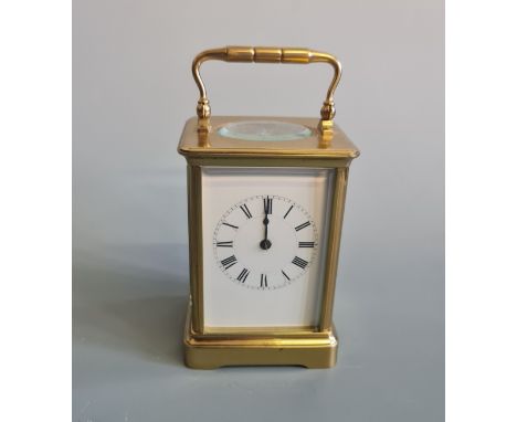 A carriage clock with handle to top and Roman numeral to face, marking to back HJE with central bird, approx. height 14cm. IM
