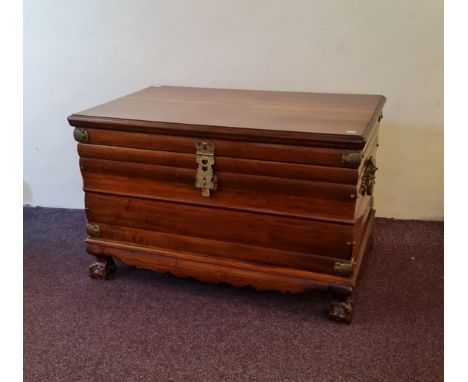 An African teak Iroko Kist trunk, with brass fittings and handles, on claw and ball feet, 65cm x 103cm x 64cm. IMPORTANT: Onl