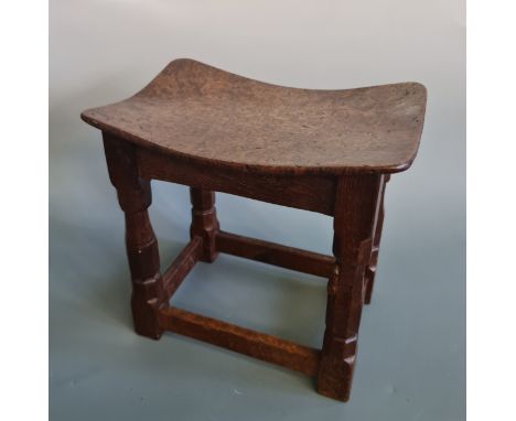 A Robert Mouseman Thompson of Kilburn stool, with burr oak saddle seat and oak four leg base, one leg featuring small carved 