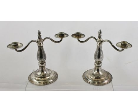 GUILD OF HANDICRAFT A PAIR OF WROUGHT SILVER TWO-BRANCH CANDELABRUM, each with a central fixed flame finial, turned spot hamm
