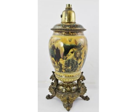 AN EARLY 20TH CENTURY ZSOLNAY EARTHENWARE GILT METAL MOUNTED OIL LAMP, having later electrical fittings, mythical beast mount