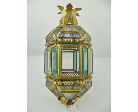 A MIDDLE EASTERN DESIGN HANGING LANTERN having decorative brass frame with tinted glass panels, 48cm high 