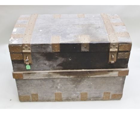 A VICTORIAN METAL BANDED STORAGE TRUNK with iron carrying handles, the hinged lid opening to reveal leather harness and leath