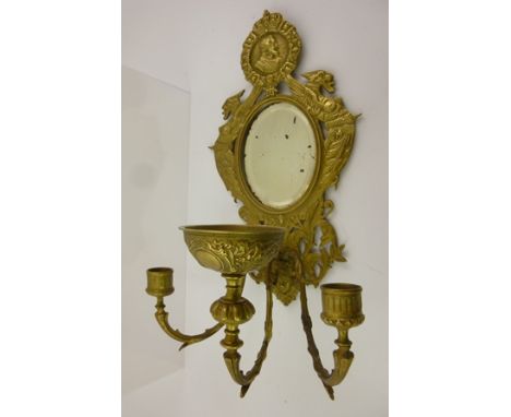 A 19TH CENTURY CONTINENTAL GILT METAL GIRANDOLE with crowned portrait to the crest, the oval bevel plate flanked by exotic cr