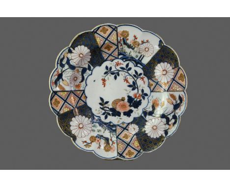 MID-18TH CENTURY CHELSEA PORCELAIN PLATE, the lobed dish hand-painted in the Imari palette with a central floral spray within