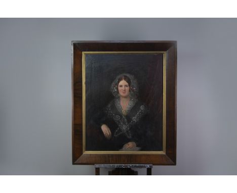 VICTORIAN SCHOOL HALF LENGTH PORTRAIT OF A LADY IN A BLACK DRESS WITH WHITE LACE COLLAR AND CAP, SEATED ON A SOFA Oil on canv