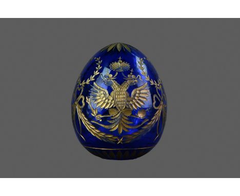 20TH CENTURY FABERGÉ PARCEL-GILT AND BLUE GLASS EGG, cut with Russian Imperial double-headed eagles interspersed with foliate