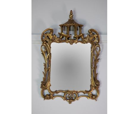 20TH CENTURY GILT WALL MIRROR, in Chinese Chippendale style, with pagoda top and pierced leaf and scroll decoration around th
