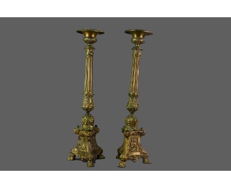 PAIR OF MID-19TH CENTURY BRASS CANDLESTICKS,with urn sconce over a fluted tapered column, and tripartite base on three paw fe