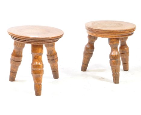 Two vintage 20th century elm wood milking low stools. Circular form top with chunky turned  baluster legs to each. Measures a