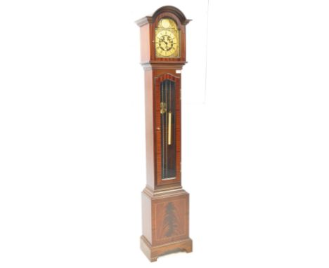Contemporary tempus fugit longcase clock with decorative brass dial set within a mahogany trunk and hood.  Features an ornate