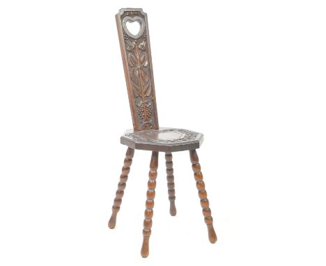 An early 20th century mahogany bobbin leg Welsh spinning stool chair. The chair raised on turned bobbin legs. Having carved b