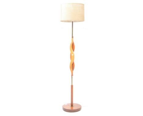 A vintage 20th century teak and brass floor standing standard lamp light. Light fixing to top with abstract teak curved panel