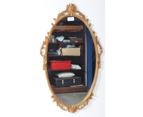 A vintage 20th century French gilt reproduction wall mirror. The mirror featuring scrolled acanthus design gilt frame. Measur