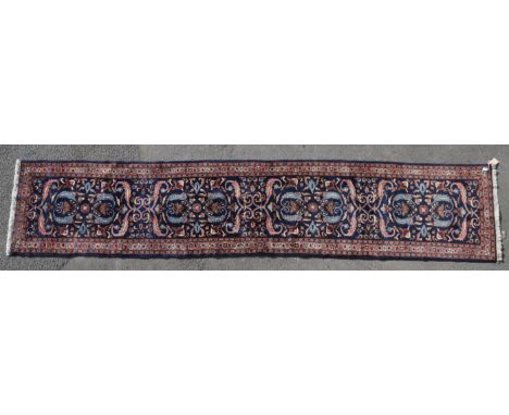 A vintage 20th century Persian Islamic Lilihan Armenibaff carpet floor runner. Having a deep blue central panel, with repeati