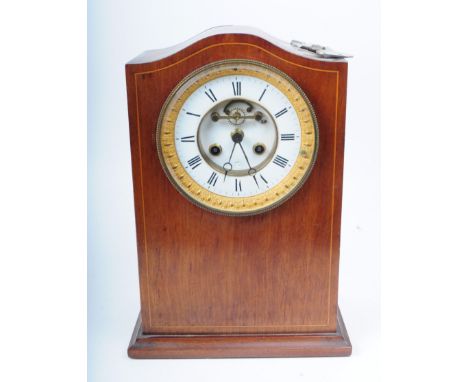 An early 20th century Edwardian mahogany cased mantel clock. The clock having an eight day movement set within a mahogany lin