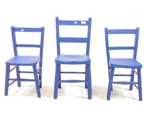 A group of three vintage 20th century painted child size chairs. Elm wood with saddle seats, tapering supports united by peri