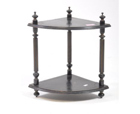 An 19th century Victorian ebonised corner stand / plant shelf, featuring three turned supports and two shelf tiers with carve