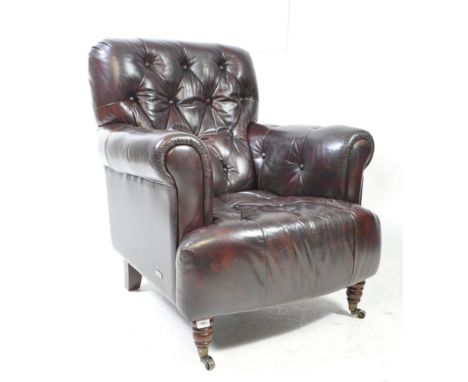 A vintage style burgundy leatherette Chesterfield armchair. Button back and seat with rolled elbow rests. With turned front l