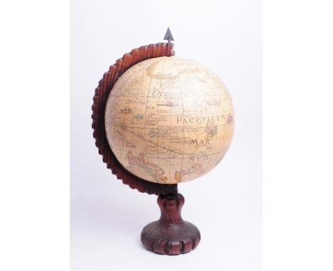 A vintage 20th century black forest style table top globe. Revolving world with carved wooden arm and circular base 