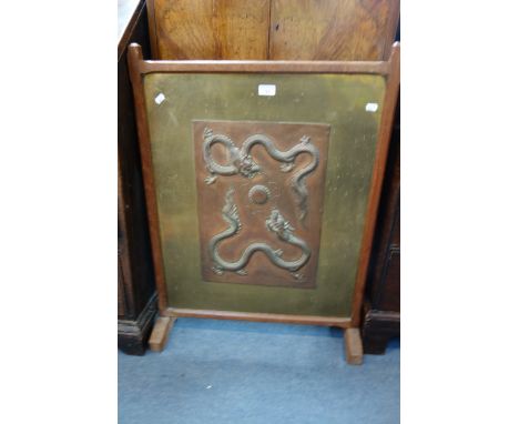 A CHINESE REPOUSSE COPPER PANEL depicting two dragons chasing a flaming pearl, mounted as a fire screen