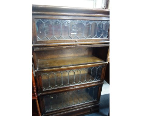 AN OAK GLOBE WERNICKE FOUR SECTION BOOKCASE with leaded glazed doors, 147cm high x 87cm wide