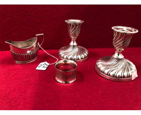 A PAIR OF LOADED HALLMARKED SILVER CANDLESTICKS, A JUG AND NAPKIN RING. 