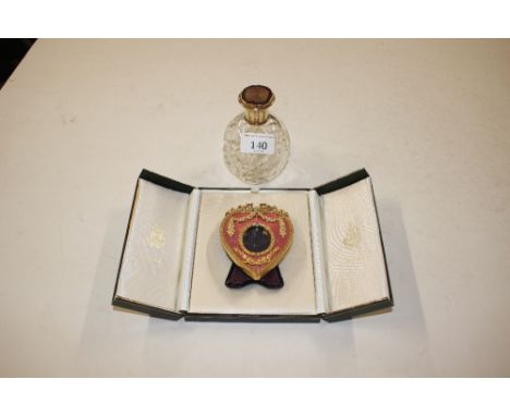 A cut glass and enamel decorated globular sent bottle and a Kitney &amp; Co gilt and enamel decorated heart shaped easel phot