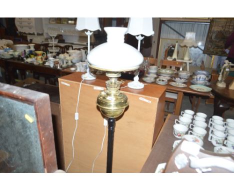 An oil lamp converted to electricity with milk glass shade 