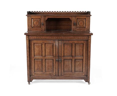 An Arts &amp; Crafts oak side cabinet or sideboard, the superstructure with a pierced gallery and two panelled cupboard doors