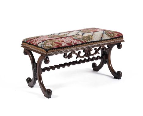 A Victorian mahogany piano duet stool with a tapestry seat, the rectangular tapestry seat over a fret carved apron and raised