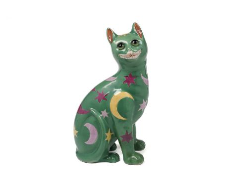 A Wemyss-style earthenware figure of a cat, with inset green glass eyes, decorated with yellow, pink, and puce stars and cres