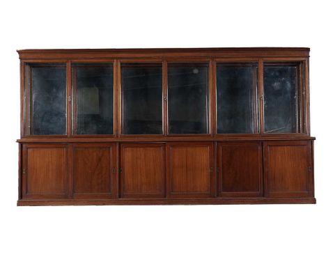 A large early 20th Century mahogany shop display cabinet, the cabinet with a moulded cornice over six glazed cupboard doors e