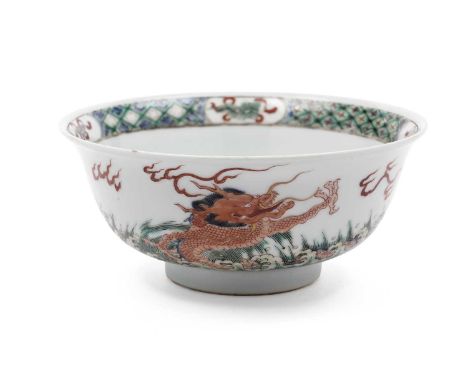 A Chinese famille vert dragon bowl in Kangxi style, decorated with dragons, waves, and rocks, the interior with a carp, 20cms
