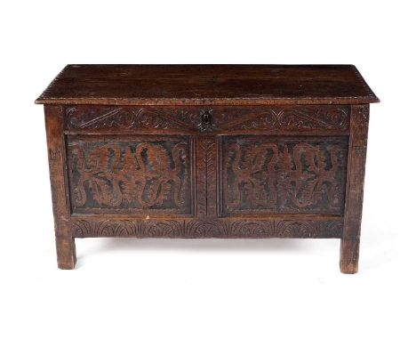 An 18th Century oak blanket box or coffer, the rectangular two-plank top with a carved scalloped edge opening to reveal a fit