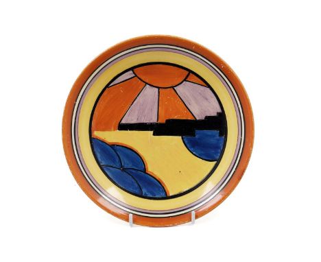 A Clarice Cliff Bizarre ‘Sunray’ pattern plate, circa 1929/30, decorated with a stylised skyscraper with orange and purple su