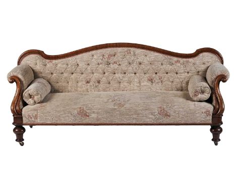 A Victorian carved walnut button back upholstered sofa, upholstered in floral tapestry material, with a serpentine shaped bac