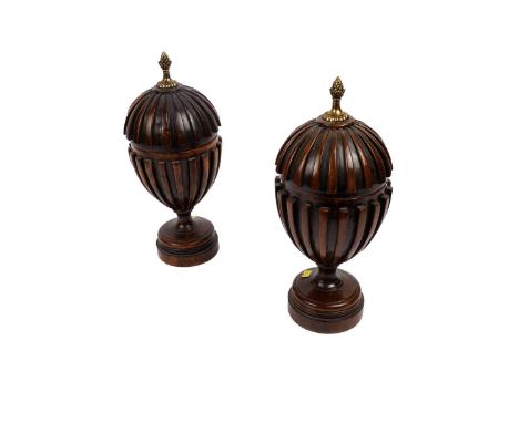 A pair of Regency-style mahogany urns, late 20th Century, with brass acorn finial, reeded exterior, raised on circular moulde