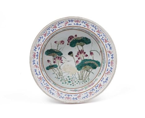 A Chinese Famille Rose circular basin, the interior painted with egrets walking amongst lotus plants, the sides with peonies 